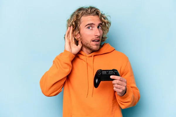 Jovem Caucasiano Jogando Com Controlador Videogame Isolado Fundo Azul Tentando — Fotografia de Stock