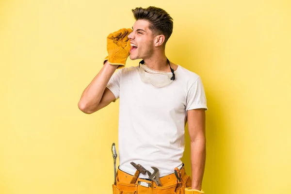 Jovem Eletricista Caucasiano Homem Isolado Fundo Amarelo Gritando Segurando Palma — Fotografia de Stock