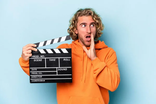 Young Caucasian Man Holding Clapperboard Isolated Blue Background Saying Secret — Stock Photo, Image