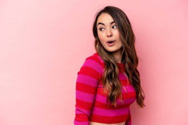 Pembe arka planda soyutlanmış beyaz bir kadın. Gülümsüyor, neşeli ve keyifli görünüyor..