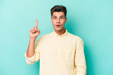 Kafkasyalı genç adam mavi arka planda izole edildi. Harika bir fikri var, yaratıcılık kavramı..