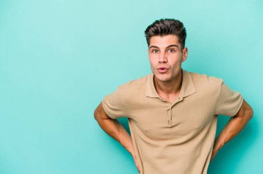 Kafkasyalı genç adam mavi arka planda izole edilmişti. Gördüğü bir şey yüzünden şok olmuştu..