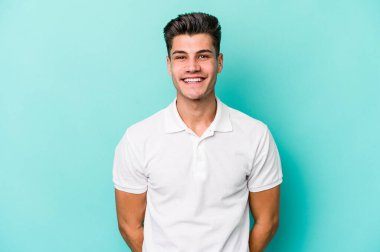 Mavi arka planda izole edilmiş genç beyaz adam mutlu, güler yüzlü ve neşeli.