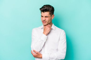 Mavi arka planda izole edilmiş genç beyaz adam virüs ya da enfeksiyon yüzünden boğazında ağrı hissediyor..