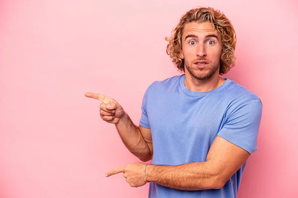 Jonge Blanke Man Geïsoleerd Roze Achtergrond Geschokt Wijzend Met Wijsvingers — Stockfoto
