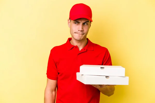 Young Delivery Caucasian Man Holding Pizzas Isolated Yellow Background Confused — ストック写真