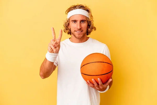 Young Basketball Player Caucasian Man Isolated Yellow Background Showing Number — Zdjęcie stockowe
