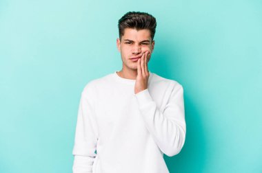 Mavi arka planda izole genç beyaz adam güçlü bir diş ağrısı, azıdişi ağrısı var..