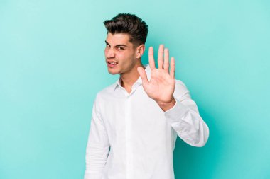 Mavi arka planda izole edilmiş genç beyaz adam tiksinti belirtisi gösteren birini reddediyor..