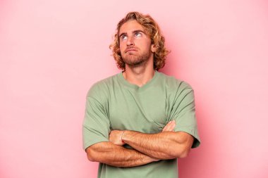 Pembe arka planda izole edilmiş genç beyaz adam tekrarlanan bir görevden bıktı..