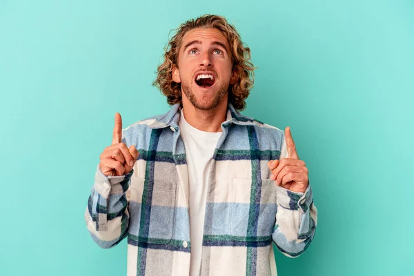 Jonge Kaukasische Man Geïsoleerd Blauwe Achtergrond Wijzend Ondersteboven Met Geopende — Stockfoto