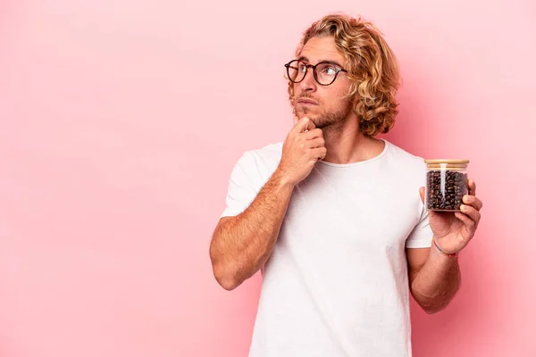 Young Caucasian Man Holding Coffee Jar Isolated Pink Background Looking — Stockfoto
