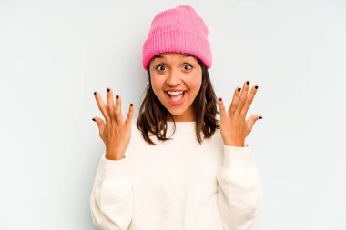 Genç İspanyol kadın mavi arka planda izole edilmiş. Düşünceli bir şekilde bir fotokopi odasına bakıyor. Ağzını eliyle kapatıyor..