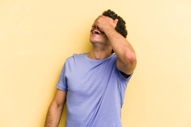 Sarı arka planda izole edilmiş genç beyaz adam ellerini başının üstünde tutarak neşe içinde gülüyor. Mutluluk kavramı.