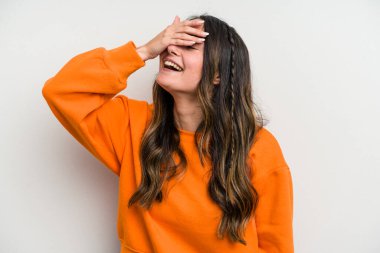 Beyaz arka planda soyutlanmış beyaz bir kadın ellerini başının üstünde tutarak neşeyle gülüyor. Mutluluk kavramı.