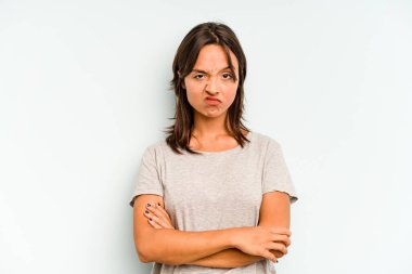 Mavi arka planda izole edilmiş genç İspanyol kadın yüksek sesle gülüyor elini göğsüne koyuyor..