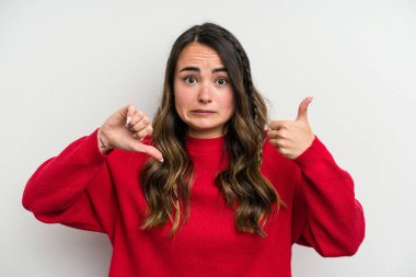Beyaz arka planda izole edilmiş genç beyaz bir kadın baş parmağını kaldırıyor ve baş parmağını aşağı gösteriyor, zor seçim konsepti.