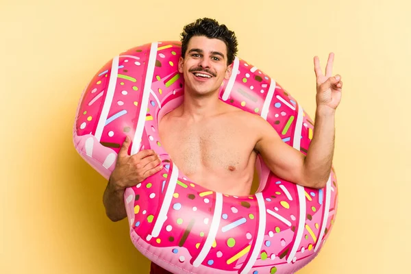 Young Caucasian Man Holding Inflatable Donut Isolated Yellow Background Joyful — 图库照片