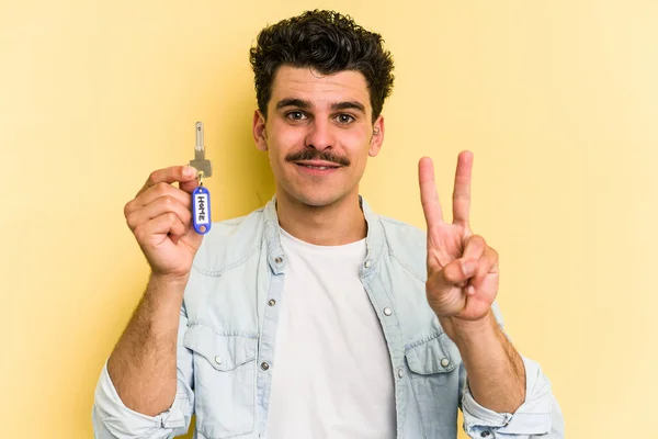 Young Caucasian Man Holding Home Keys Isolated Yellow Background Showing — Stock Fotó