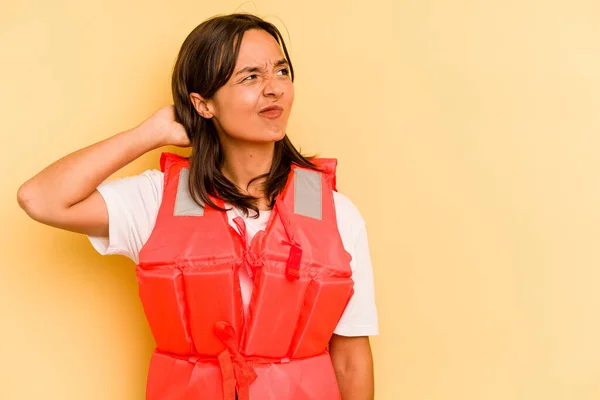 Ung Latinamerikansk Kvinna Håller Flytväst Isolerad Gul Bakgrund Vidrör Baksidan — Stockfoto