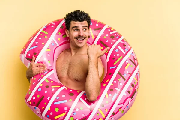 Young Caucasian Man Holding Inflatable Donut Isolated Yellow Background Points — ストック写真
