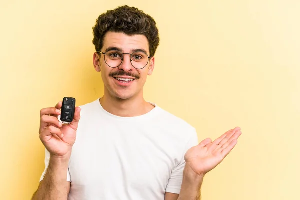 Young Caucasian Man Holding Car Keys Isolated Yellow Background Showing — Foto de Stock