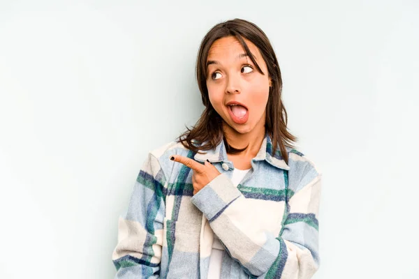 Young hispanic woman isolated on blue background blows cheeks, has tired expression. Facial expression concept.