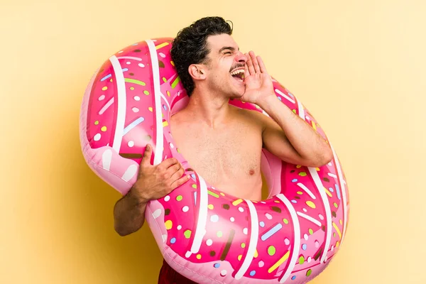 Young Caucasian Man Holding Inflatable Donut Isolated Yellow Background Shouting — 图库照片