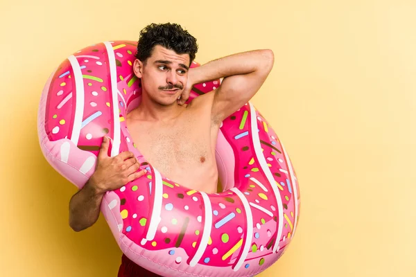 Young Caucasian Man Holding Inflatable Donut Isolated Yellow Background Touching — 图库照片