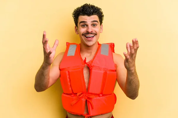 Young Caucasian Man Wearing Life Jacket Isolated Yellow Background Receiving — Stock Photo, Image