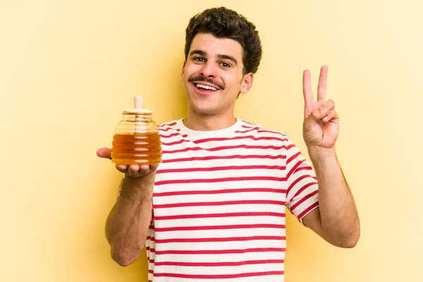 Young Caucasian Man Holding Honey Jar Isolated Yellow Background Joyful — Stockfoto