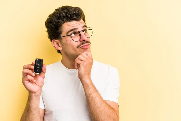 Young Caucasian Man Holding Car Keys Isolated Yellow Background Looking —  Fotos de Stock