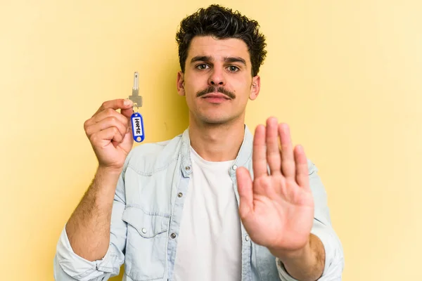 Young Caucasian Man Holding Home Keys Isolated Yellow Background Standing — Stock fotografie