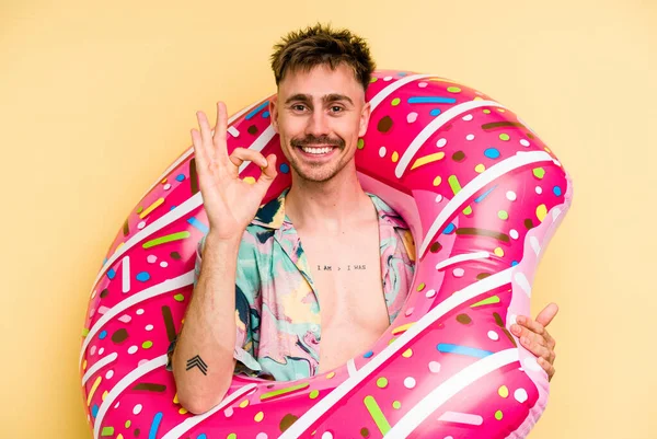 Young Caucasian Man Holding Inflatable Donut Isolated Yellow Background Cheerful — Stok fotoğraf