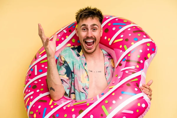 Young Caucasian Man Holding Inflatable Donut Isolated Yellow Background Receiving — Foto Stock