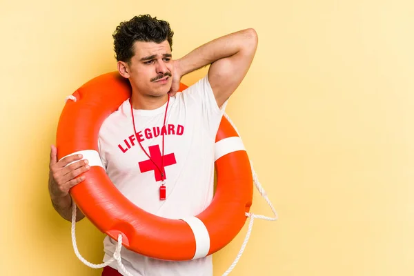 Young Caucasian Lifeguard Man Isolated Yellow Background Touching Back Head — 图库照片