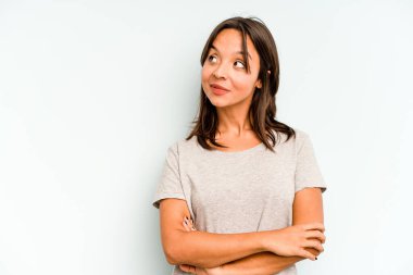 Genç İspanyol kadın mavi arka planda izole edilmiş, ağlıyor, bir şeyden mutsuz, acı ve kafa karışıklığı konsepti..