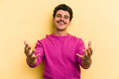 Sarı arka planda izole edilmiş beyaz bir genç hoş bir yüz ifadesi sergiliyor..