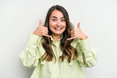 Beyaz arka planda izole edilmiş genç beyaz kadın parmaklarıyla bir cep telefonu hareketi gösteriyor..