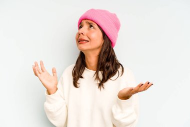 Mavi arka planda izole edilmiş genç İspanyol kadın karnına dokunuyor, nazikçe gülümsüyor, yemek yiyor ve tatmin oluyor..