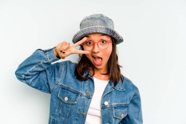 Mavi arka planda izole edilmiş genç İspanyol kadın avuç içi fotokopi alanını tutmaktan etkilenmiş..