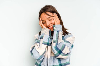 Mavi arka planda izole edilmiş genç İspanyol kadın gökyüzüne haykırıyor, yukarı bakıyor, hayal kırıklığına uğramış..