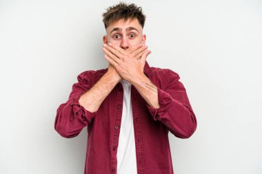 Beyaz arka planda izole edilmiş genç beyaz bir adam ağzı kapalı ve elleri endişeli görünüyor..