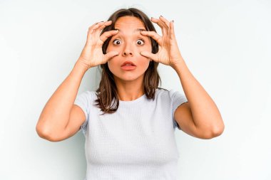 Mavi arka planda izole edilmiş genç İspanyol kadın bir numarayı parmağıyla gösteriyor..