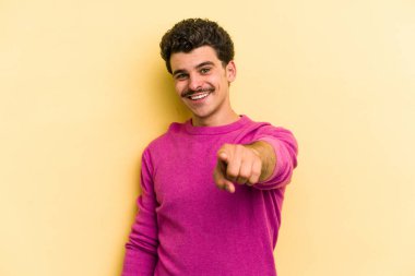 Sarı arka planda izole edilmiş genç beyaz adam öne bakan neşeli gülücükler.