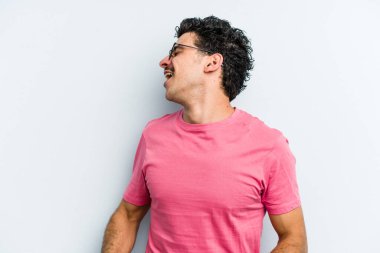 Genç beyaz adam mavi arka planda izole edilmiş dans ediyor ve eğleniyor..