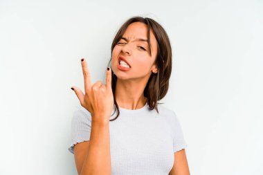 Mavi arka planda izole edilmiş genç İspanyol kadın gizli bir sıcak fren haberi veriyor ve yana bakıyor.