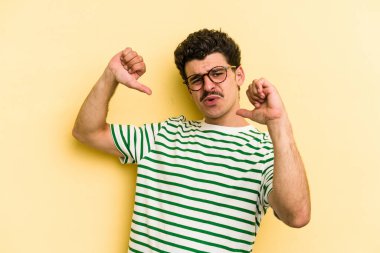 Sarı arka planda izole edilmiş genç beyaz adam gururlu ve kendinden emin hissediyor, örnek olarak.