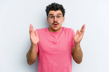 Kafkasyalı genç bir adam mavi arka planda izole edilmiş. Bir fikri, ilham verici bir fikri var..