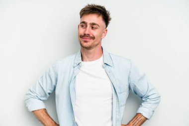 Beyaz arka planda izole edilmiş genç beyaz adam hedeflere ve amaçlara ulaşmayı hayal ediyor.